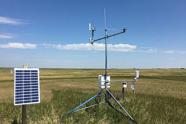 A picture of a weather device in a field.